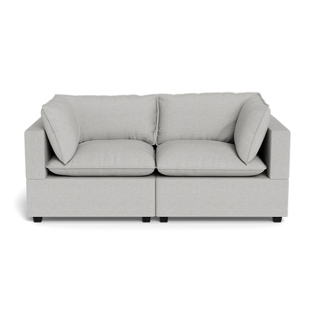 The Kova Pillow Cushion Sofa 86" is a modern light gray two-seater with square armrests, two seat cushions, and two back cushions, displayed against a black background.