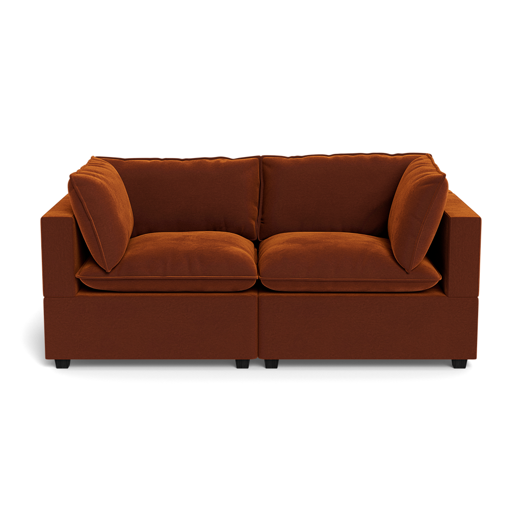 The Kova Pillow Cushion Sofa 86" is a modern dark orange velvet sofa with two seat and two back cushions, pictured from the front against a black background.