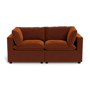The Kova Pillow Cushion Sofa 86" is a modern dark orange velvet sofa with two seat and two back cushions, pictured from the front against a black background.