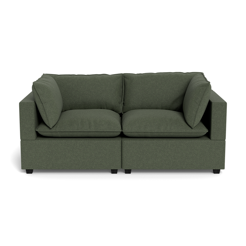 The Kova Pillow Cushion Sofa 86" is a modern dark green fabric sofa with thick seat and back cushions, two large side pillows, and square armrests, shown from the front against a black background.