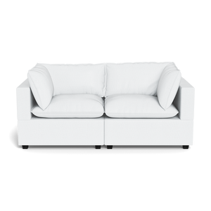 The Kova Pillow Cushion Sofa 86" is a modern white two-seater with square arms and plush cushions, shown against a plain black background.