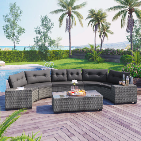 The 8 Pieces Outdoor Wicker Round Sofa Set, featuring a curved design with dark cushions and a rectangular glass-top coffee table, graces a wooden deck next to a pool. The area is surrounded by palm trees, lush greenery, and offers a scenic ocean view.