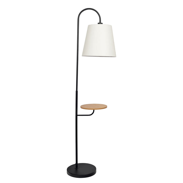 The Seoul Floor Lamp features a black metal stand with a curved arm, a white lampshade, and a mid-height circular wooden shelf. It includes a round black base and comes with a rotary switch.