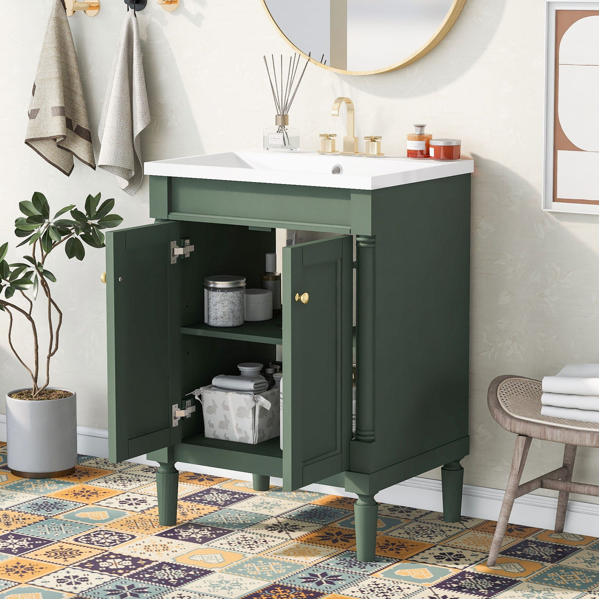 Below a round mirror, the Bathroom Vanity With Top Sink showcases its green 2-tier storage cabinet with open doors displaying shelves holding containers. Colorful mosaic tiles adorn the floor, and towels are hung on an adjacent wall.