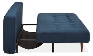 Side view of the Deco Convertible Sleeper Sofa in a partially extended position. The composition shows the metal frame and support legs underneath, with the backrest folded down to create a flat bed surface. The tufted upholstery is visible.