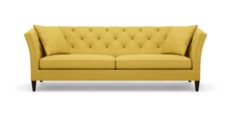 The Shelton 98" Sofa features a tufted backrest and two seat cushions in a mustard yellow color. It is designed with flair arms and rests on dark wooden legs.