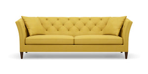 The Shelton 98" Sofa features a mustard yellow tufted design with two seat cushions and two back cushions. It has high arms and dark wooden legs, all set against a plain white background.