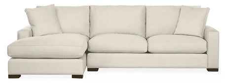 The Metro Sofas with Chaise is a spacious, light beige sectional featuring a left-sided chaise. It boasts thick cushions and rests on short, dark wooden legs, with an array of matching cushions along the back.