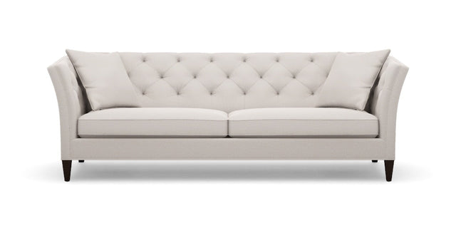 The Shelton 98" Sofa is a modern, light gray piece with a tufted backrest and includes two matching cushions. It showcases a symmetrical design enhanced by flared arms and sits on dark wooden legs.