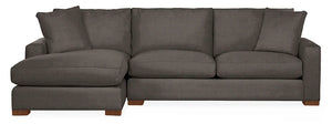 The Metro Sofas with Chaise is a dark gray sectional featuring clean lines and generously padded cushions. Designed with a left-side chaise lounge, it creates a cozy and modern seating area, supported by wooden block feet.
