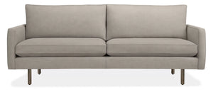 The 86" Jasper Sofa is a modern, light gray seating option with a clean and minimalist design. It features two seat cushions, two back cushions, and slim metal legs for support. With its sleek and contemporary appearance, it is well-suited for various living spaces.