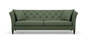 The Shelton 98" Sofa is a green, mid-century modern piece featuring a tufted backrest and angled arms. It includes two large cushions and rests on four dark wooden legs.