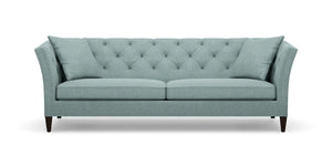The Shelton 98" Sofa is a stylish piece, featuring a tufted backrest and two seat cushions in a chic teal color. It boasts flared armrests and rests on dark wooden legs, seamlessly combining contemporary design with comfort.