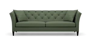 Introducing the Shelton 98" Sofa: a green tufted masterpiece accompanied by two matching cushions. This design boasts high arms and a sleek, modern aesthetic, complete with dark wooden legs and a cozy, plush appearance.