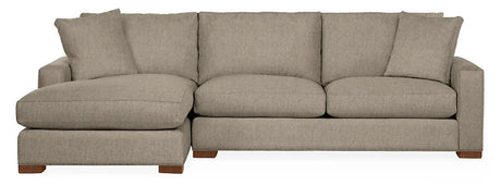 The Metro Sofas with Chaise is a beige sectional sofa featuring a left-side chaise lounge. It includes three seat cushions, three back cushions, and two matching throw pillows. The sofa is supported by wooden legs and showcases a simple, modern design.
