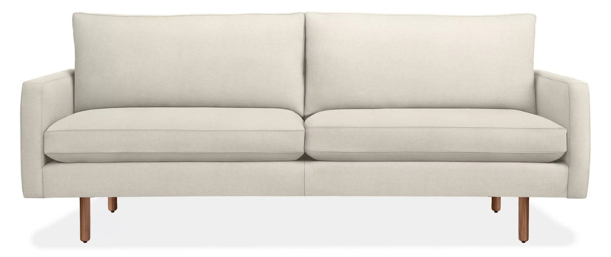 The 86" Jasper Sofa is a modern, minimalist piece featuring a beige color with a straight back and two seat cushions. It boasts sleek armrests and wooden legs, offering a contemporary look, all set against a plain white background.