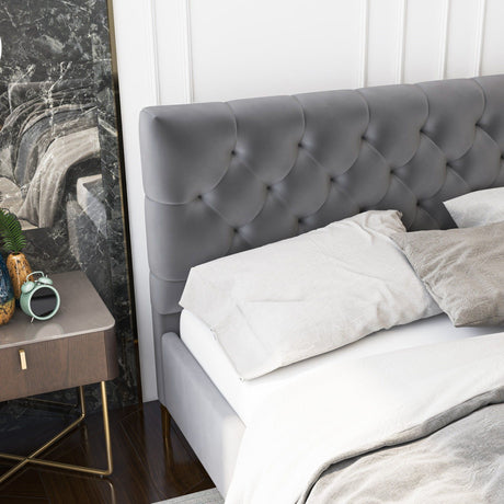 The Bailey Elegant Design Bed with gray tufted headboard is beside a wooden bedside table holding a green plant, alarm clock, and book. The room showcases a marble accent wall and hardwood flooring.