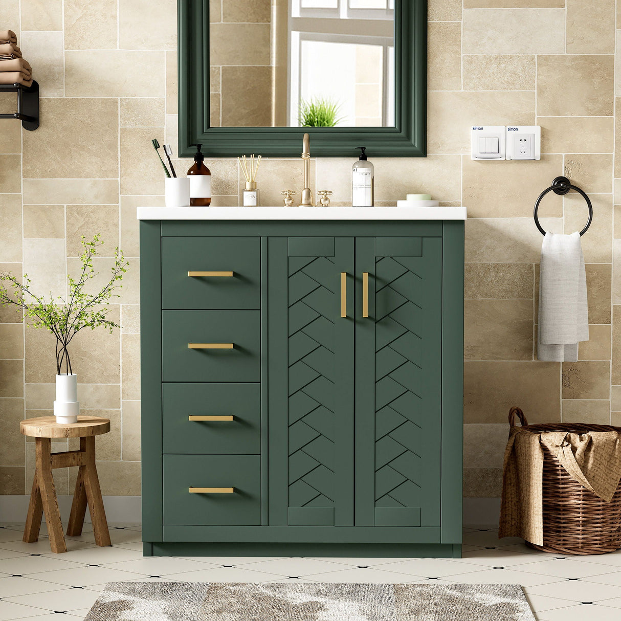 A modern bathroom showcases a green Ceramic Sink Combo Freestanding Vanity with gold handles and chevron-patterned doors. It features a white countertop with toiletries, a round wooden stool, a basket, and a towel. Beige tiled walls complement the large mirror above the sink.