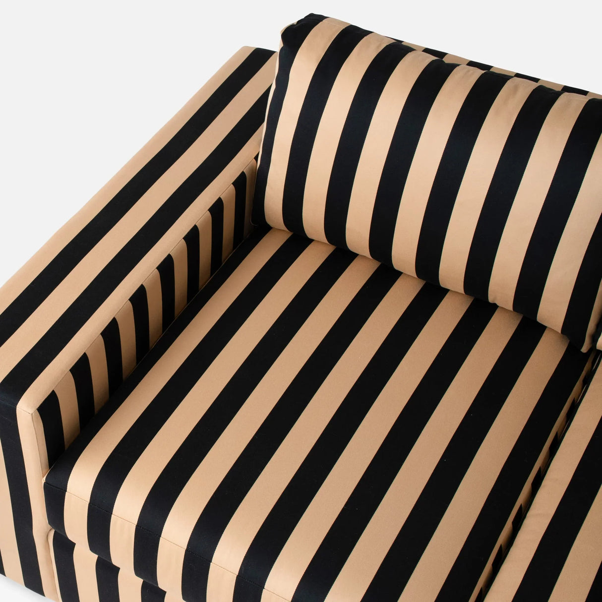 A close-up of the Marc Striped Sofa showcases its bold black and beige vertical stripes, featuring the armrest and a cushion that highlight the striking, contrasting pattern on the fabric.