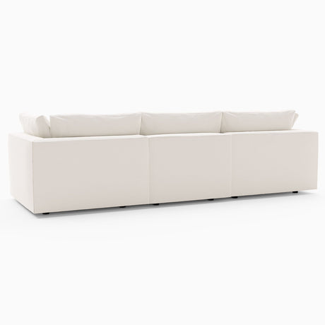 The Harmony Modular 3 Piece Sofa, featuring a large and modern white sectional design with minimalist aesthetics and low cushions, is showcased against a plain white background. This sofa comprises three interconnected segments, offering a sleek and contemporary look.
