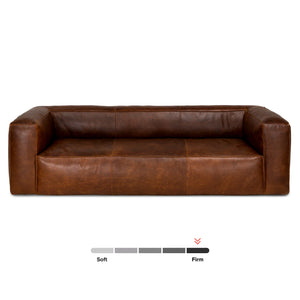 Presenting the Cigar 92" Leather Sofa in Rawhide Tan, featuring a brown leather finish with a boxy design and wide armrests. This sofa is equipped with an indicator that displays its position on the softness-to-firmness scale.