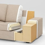 Cutaway view of the KIVIK Sofa in beige with light wood accents, highlighting its internal structure, including cushions, frame, and springs. The image provides a detailed look at parts of the armrest and base against a plain background.