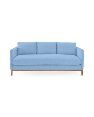 A contemporary Barton Sofa in a light blue hue featuring three back cushions and wooden legs, showcasing a sleek, minimalist design against a plain white background.