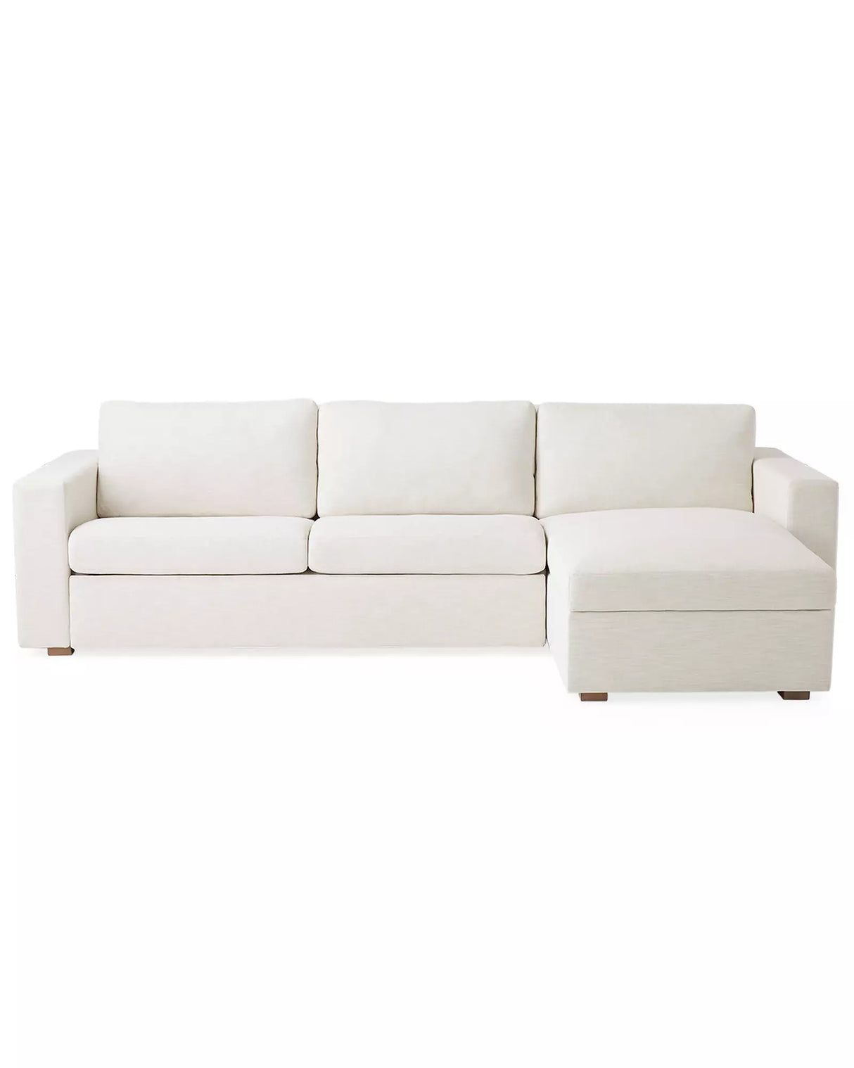 The Conover Sleeper Chaise Sectional is a light beige sofa featuring three cushions and a right-side chaise. It is designed with wide armrests and short wooden legs, showcased against a plain white background.