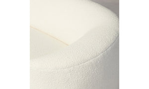 Close-up of the top corner of a rounded Chelsea Sofa in Italian Bouclé White. The bouclé fabric looks soft and plush, with a gentle curve that creates an inviting appearance. The neutral background accentuates the sofa's design.