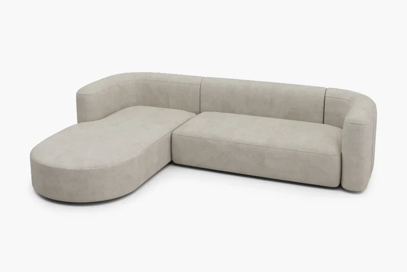Introducing the Mellow Sectional Sofa by Acanva: a contemporary L-shaped beige sofa with rounded edges, designed with a left-facing chaise and cushioned backrests, elegantly displayed against a plain white background.