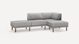 The Range Fabric 4-Piece Open Sectional Double Lounger Sofa is a modern piece in light gray, featuring three seats and an extended chaise lounge on the left. It boasts wooden legs and a minimalist design against a plain white background.