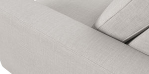 Close-up of the Rio Sofa, showcasing its light gray fabric with clean lines and visible stitching. The image highlights the armrest and backrest, emphasizing the texture and minimalist design of its upholstery.