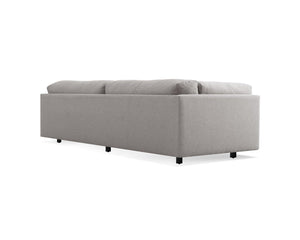 The Sunday 102-Inch Sofa is a contemporary, minimalist piece featuring a straight backrest and cushioned seating. Its design is elevated by small black legs, presenting a simple elegance ideal for modern interior spaces.
