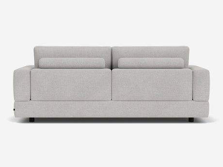 The Stage Track Sofa features a modern, light gray design with a minimalist aesthetic. It has a rectangular shape, two attached back cushions, and short black legs. The upholstery is soft and textured, making it an excellent addition to any contemporary living space.