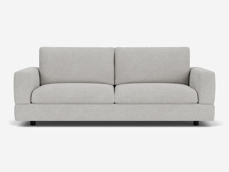 The Stage Track Sofa is a modern two-seater in light gray, featuring plush cushions and a minimalist design. It boasts square arms and a low-profile base, set against a plain white background.