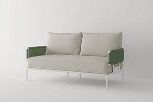 Introducing the Sylva Outdoor Modular Sofa by Acanva: a modern piece with a minimalist design, boasting beige upholstered seat and back cushions. This sofa features green, textured armrests and a sleek white metal frame, all set against a plain, light-colored background.