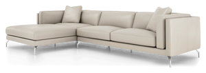 Introducing the Reade Sectional Sofa: a modern beige L-shaped sectional featuring sleek metal legs and plush cushions. Accentuated by two square throw pillows at the corners, it embodies a contemporary design.
