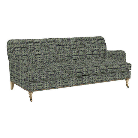 Introducing the Maggie Sofa with Brass Nailheads: This green and black patterned upholstered couch features wooden legs on wheels, showcasing a streamlined design with cushioned back and armrests, making it an ideal choice for a contemporary living room setting.