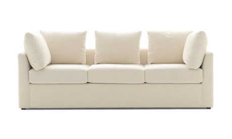 The Mitchell Gold + Bob Williams Dr Pitt Sofa is a modern, cream-colored, plush three-seater with clean lines and five matching cushions. Its minimalist design not only looks comfortable but also makes it ideal for a contemporary living room setting.